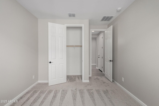 unfurnished bedroom with light carpet and a closet