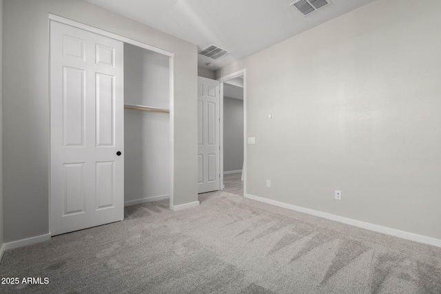 unfurnished bedroom featuring light carpet and a closet