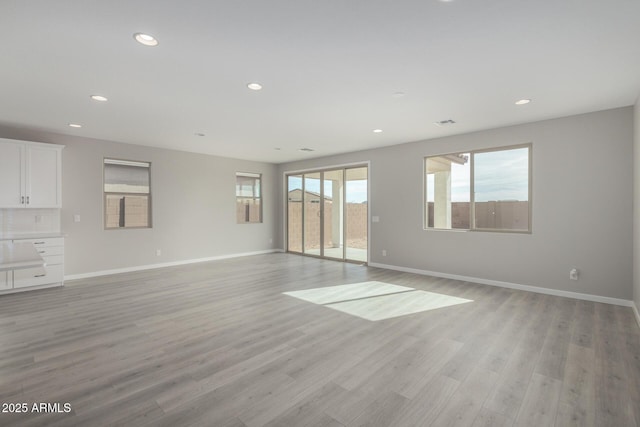 spare room with a wealth of natural light and light hardwood / wood-style floors