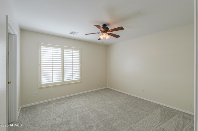 spare room with baseboards, carpet, visible vents, and ceiling fan