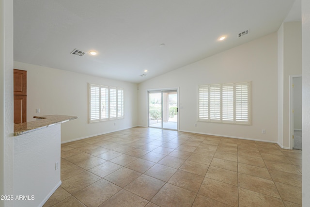 empty room with light tile patterned floors, visible vents, and baseboards