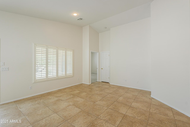 unfurnished room with light tile patterned flooring, visible vents, high vaulted ceiling, and baseboards