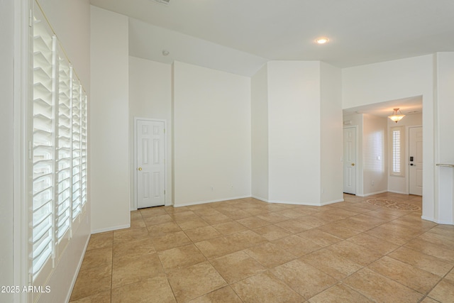 unfurnished room with high vaulted ceiling and baseboards