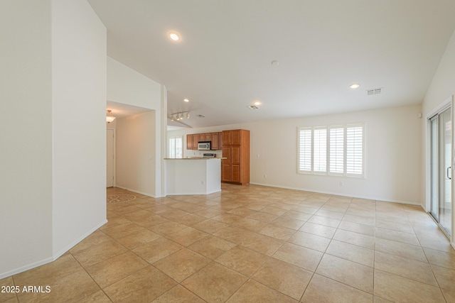 unfurnished living room featuring light tile patterned floors, visible vents, and a wealth of natural light