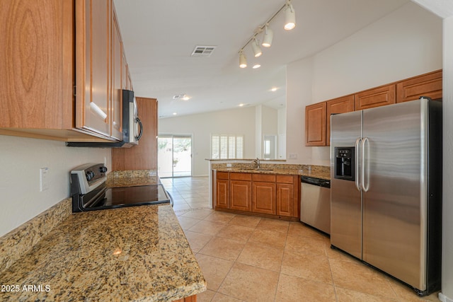 kitchen with a sink, stainless steel appliances, visible vents, and brown cabinetry