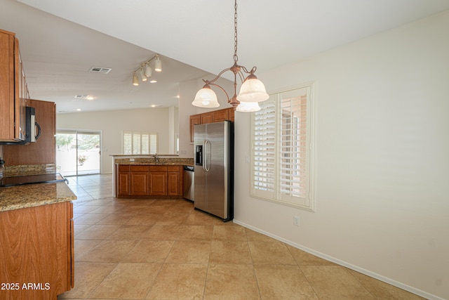 kitchen featuring lofted ceiling, brown cabinets, visible vents, and stainless steel appliances