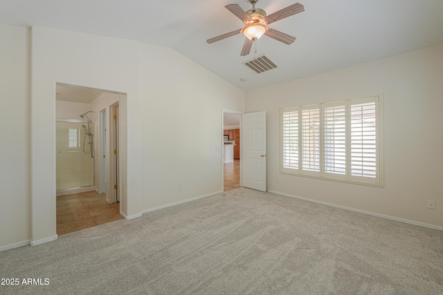 unfurnished bedroom with visible vents, baseboards, carpet flooring, and vaulted ceiling