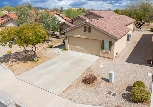 view of front facade with stucco siding, a garage, driveway, and a tile roof