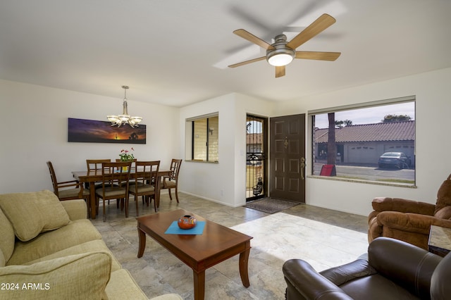 living room with ceiling fan with notable chandelier