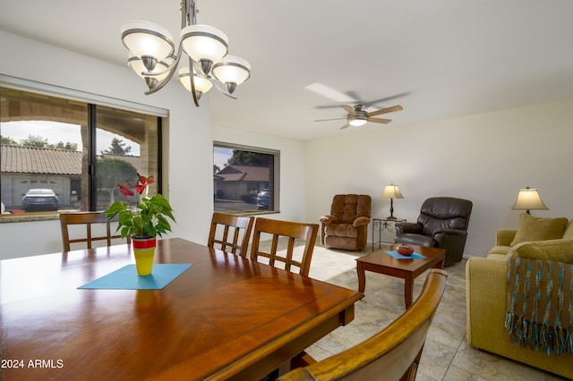 dining area featuring ceiling fan with notable chandelier