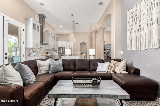 living room with arched walkways and decorative columns