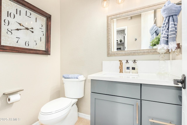 bathroom with vanity, baseboards, and toilet