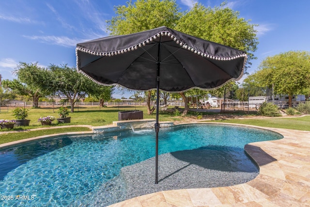 pool with a fenced backyard and a yard