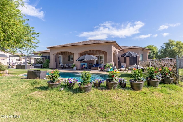 rear view of property featuring a lawn, a patio area, fence, an outdoor hangout area, and stucco siding