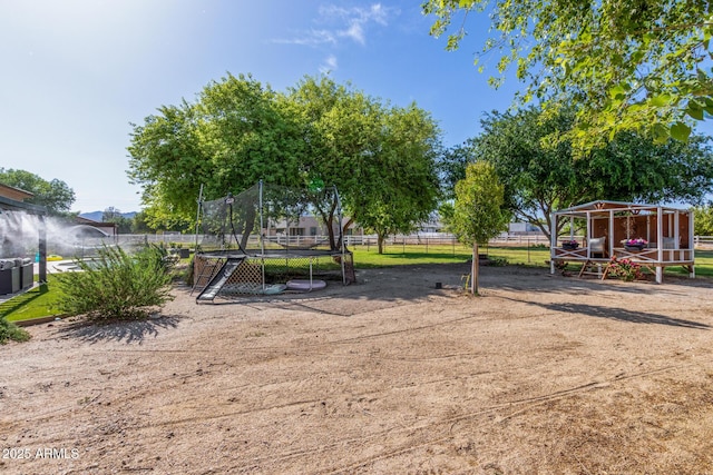 exterior space with a trampoline and fence