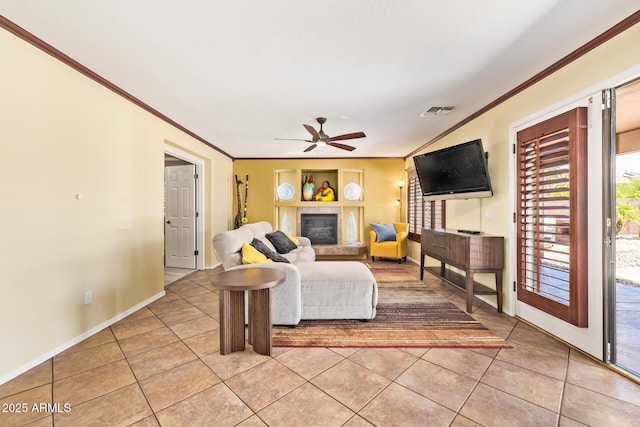 31453 N Blackfoot Dr, San Tan Valley, AZ 85143 - living area with light tile patterned flooring, ornamental molding, a ceiling fan, a fireplace, and baseboards
