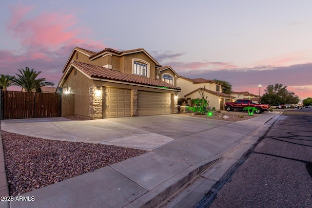 31453 N Blackfoot Dr, San Tan Valley, AZ 85143 - mediterranean / spanish-style house featuring concrete driveway, stucco siding, a tiled roof, stone siding, and a garage