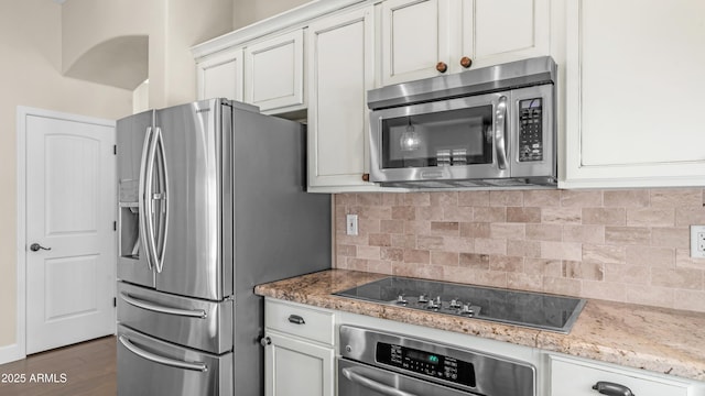 kitchen with white cabinets, appliances with stainless steel finishes, decorative backsplash, and dark wood-style floors