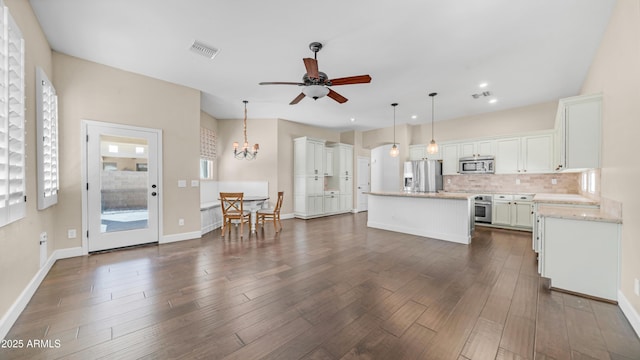 kitchen featuring visible vents, a center island, tasteful backsplash, ceiling fan with notable chandelier, and stainless steel appliances