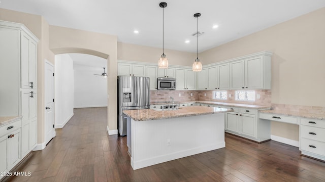 kitchen with white cabinetry, dark wood-style floors, tasteful backsplash, and stainless steel appliances