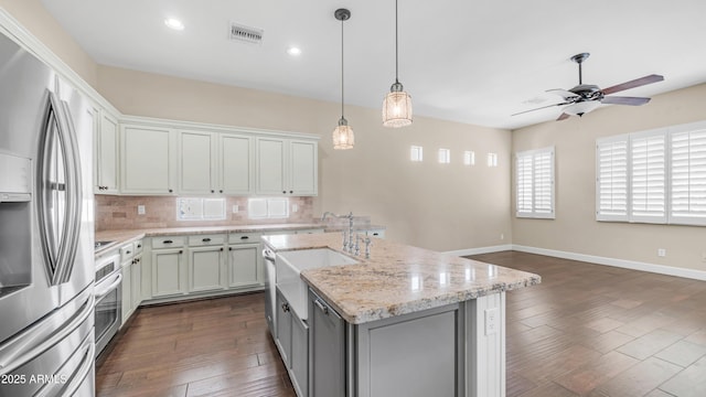 kitchen featuring visible vents, decorative backsplash, ceiling fan, a sink, and appliances with stainless steel finishes