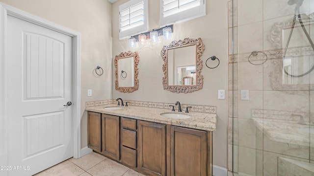 bathroom with a sink, tile patterned flooring, a tile shower, and double vanity