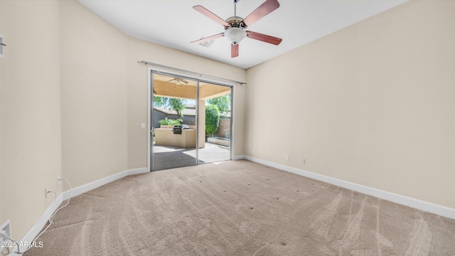 spare room with baseboards, ceiling fan, and carpet