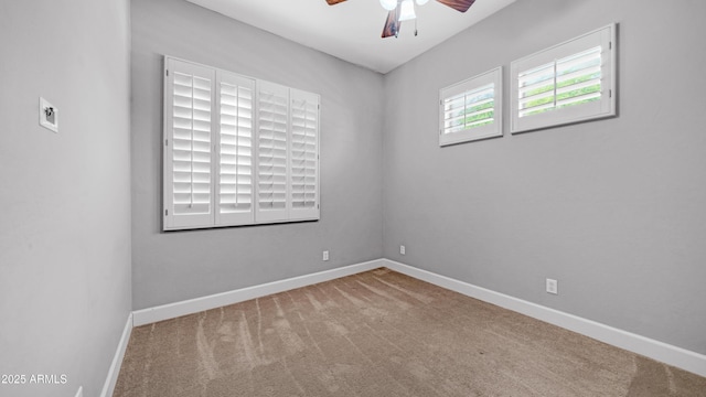 carpeted spare room with baseboards and a ceiling fan