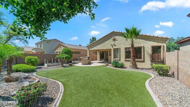 rear view of property featuring a lawn, a fenced backyard, a patio area, and stucco siding