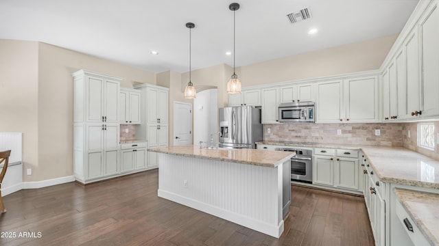 kitchen featuring stainless steel appliances, light stone countertops, visible vents, and decorative backsplash