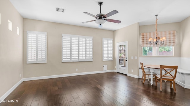 dining area featuring plenty of natural light, ceiling fan with notable chandelier, wood finished floors, and visible vents