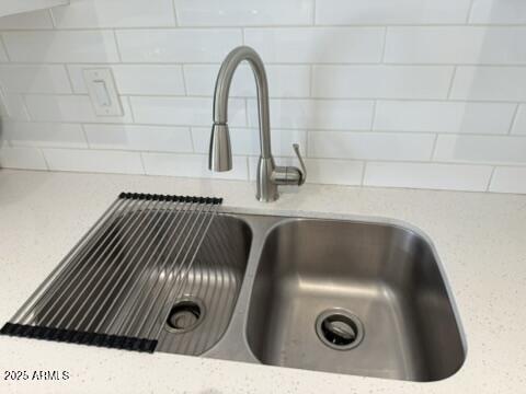interior details featuring light stone countertops and a sink