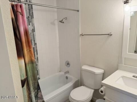 bathroom featuring shower / bath combination with curtain, toilet, and vanity