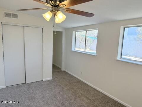 unfurnished bedroom featuring baseboards, visible vents, carpet, a closet, and ceiling fan