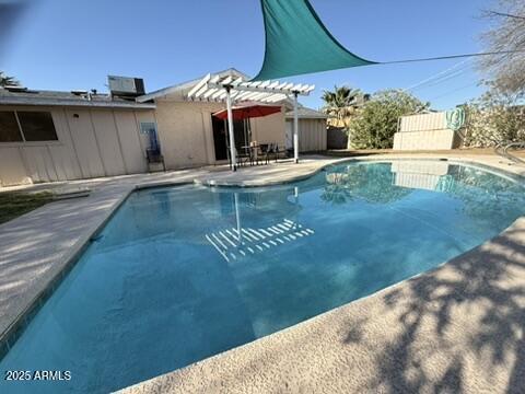 outdoor pool featuring a pergola and a patio area