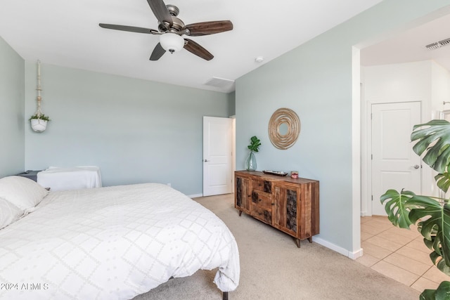 bedroom with baseboards, visible vents, and light carpet