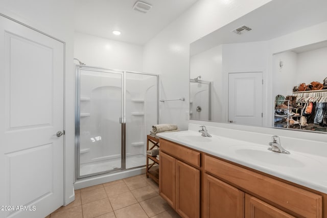 bathroom featuring a shower with door, vanity, and tile patterned floors