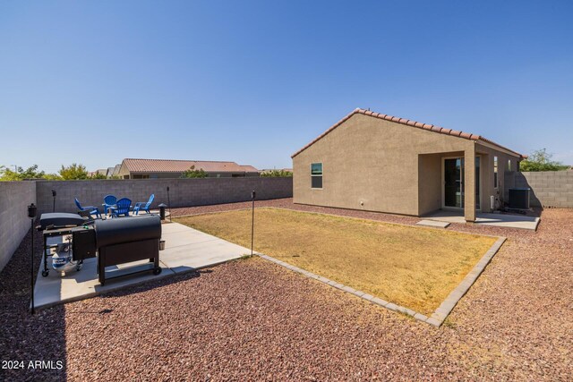 view of yard featuring a patio area, central air condition unit, and a fenced backyard