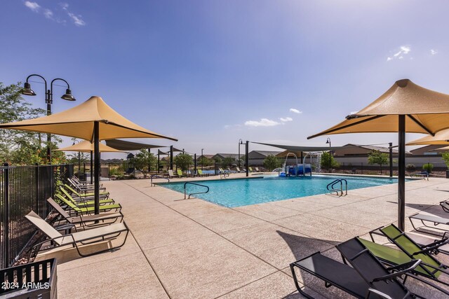 pool with a patio and fence