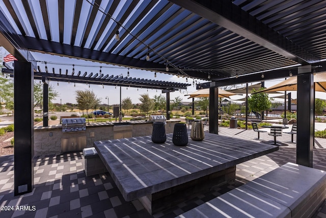 view of patio with a grill, a pergola, and exterior kitchen