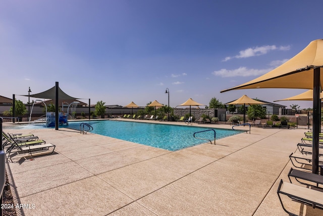 pool with a patio and fence