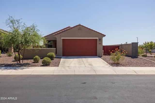 view of front of home with a fenced front yard, a garage, concrete driveway, and stucco siding