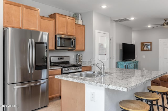 kitchen with visible vents, ceiling fan, a breakfast bar area, appliances with stainless steel finishes, and a sink