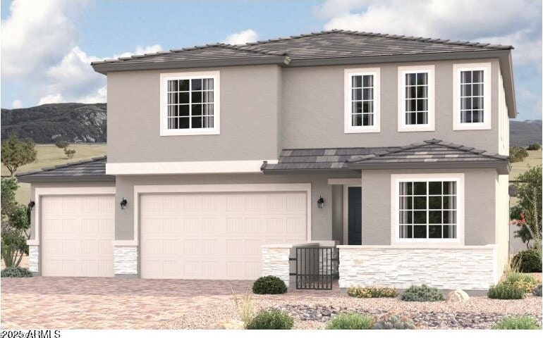 traditional-style house with stone siding, an attached garage, and stucco siding