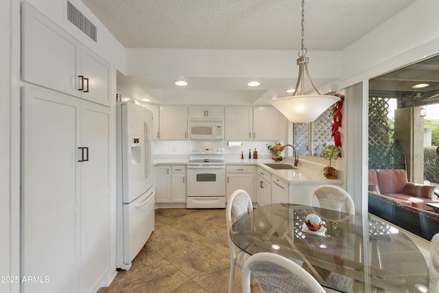 kitchen featuring pendant lighting, sink, white cabinets, white appliances, and a textured ceiling