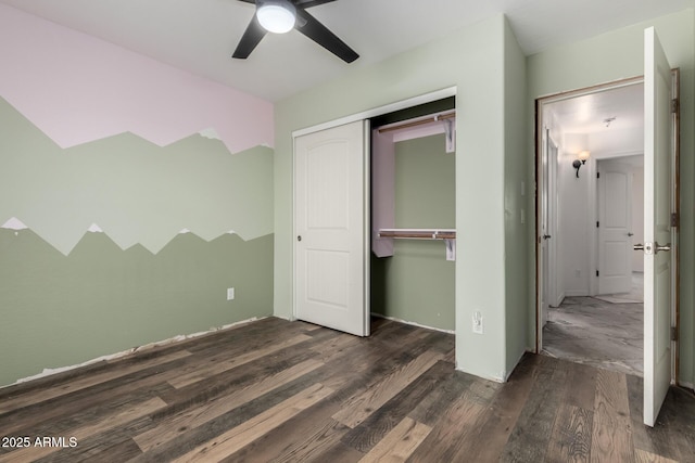 unfurnished bedroom featuring dark hardwood / wood-style floors, ceiling fan, and a closet