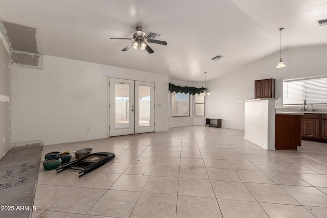 unfurnished living room with vaulted ceiling, sink, light tile patterned floors, ceiling fan, and french doors