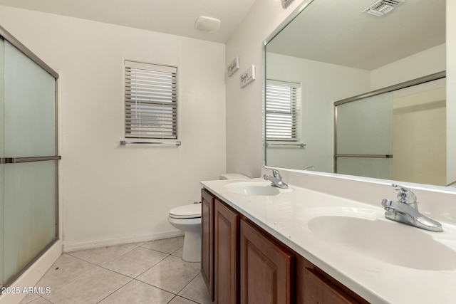 bathroom featuring vanity, a shower with shower door, tile patterned floors, and toilet