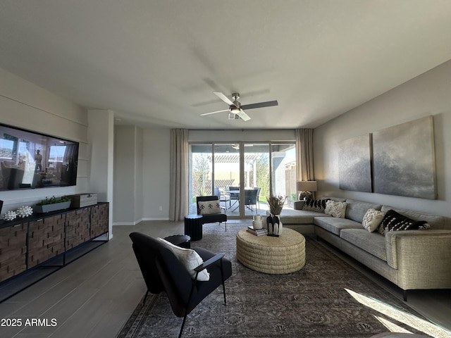 living area with ceiling fan, baseboards, and wood finished floors