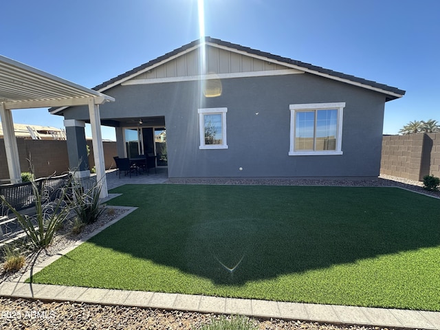 rear view of property with a lawn, a patio, fence, a pergola, and stucco siding